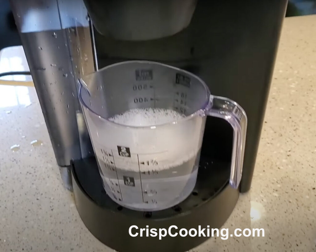 Brewed water with rests of descaler solution on keurig coffee maker