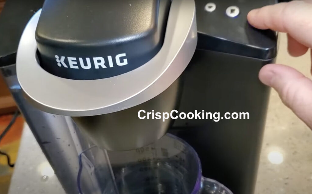 Press brew button on Keurig coffee maker
